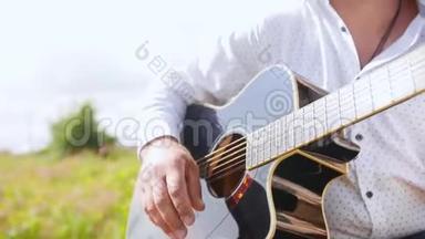 人弹吉他，唱自然.. 吉他手触摸吉他弦。 近距离射击。